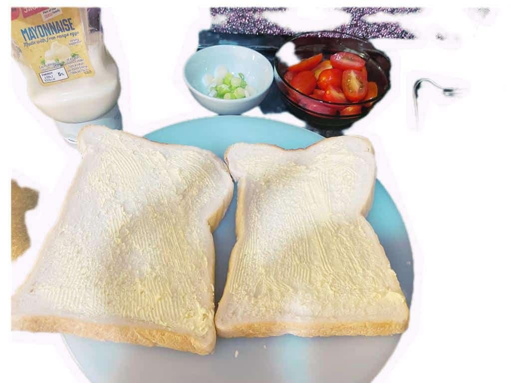 Fresh sandwich ingredients neatly displayed: 2 slices of bread, a knob of butter, boiled eggs, sliced tomato, and finely chopped spring onions—everything needed for the Golden Egg and Mayo Breakfast Sandwich.