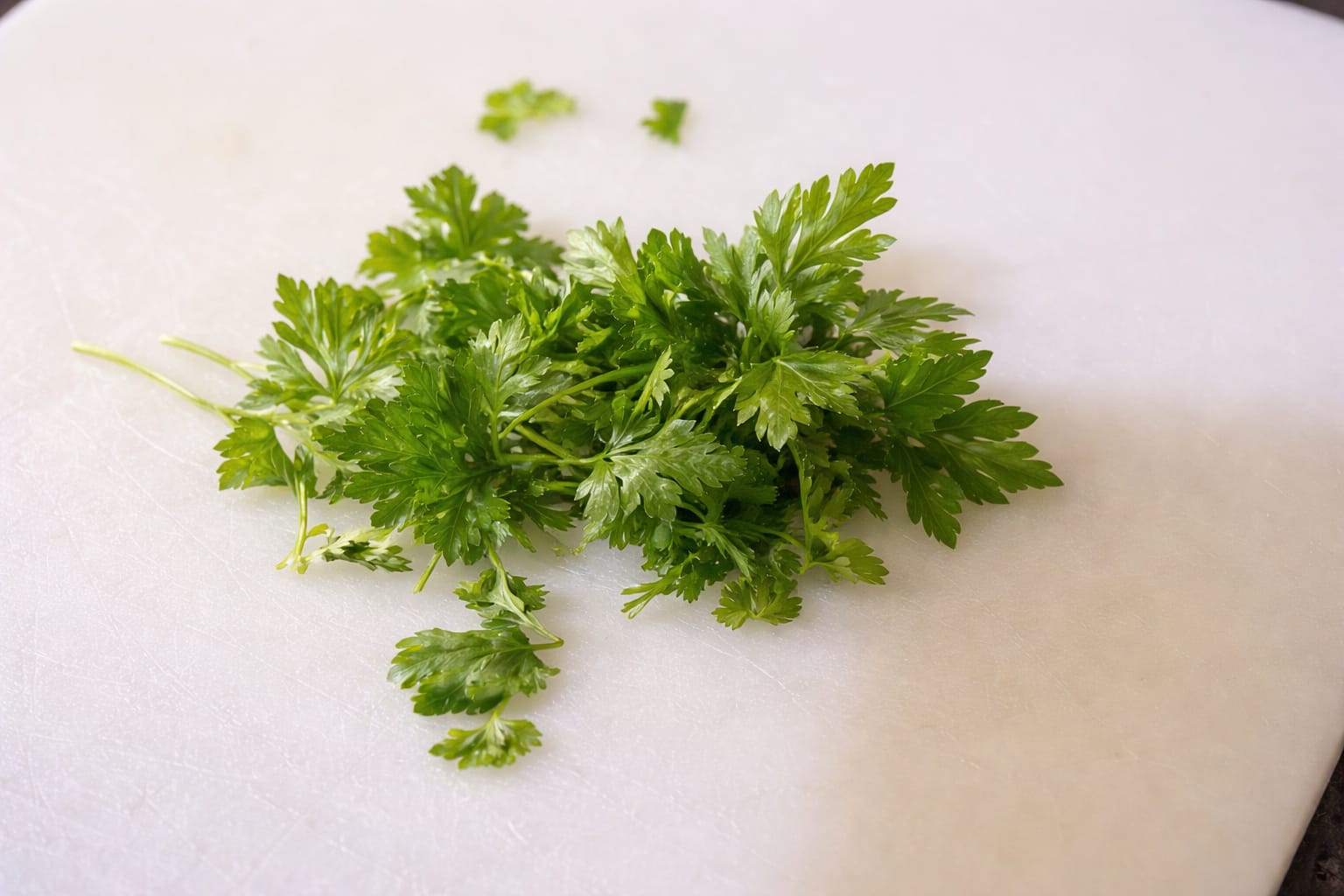 Fresh chopped parsley on a cutting board prepared for avocado egg toast topping