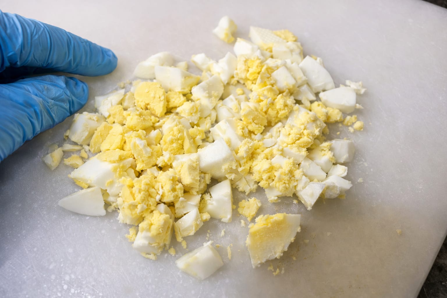 Chopped boiled eggs on a cutting board prepared for avocado egg toast topping
