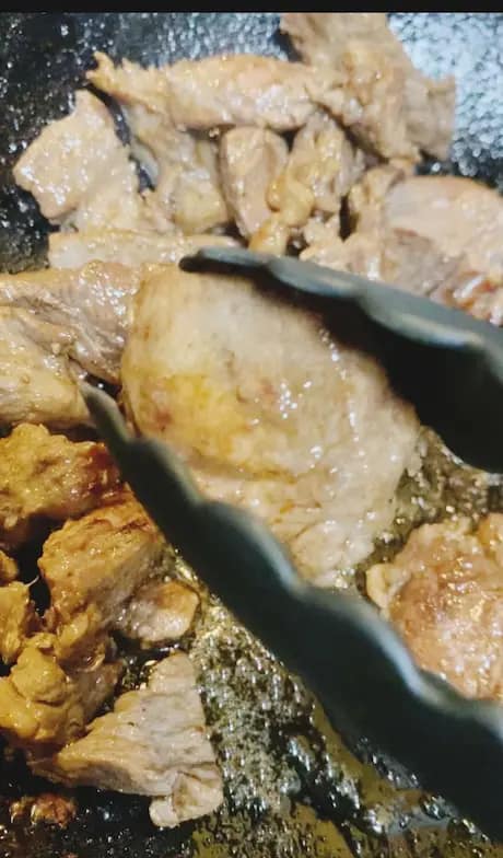 Beef frying in a pan with oil
