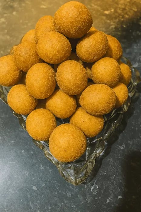 Golden cinnamon roll bites stacked on a glass plate, ready to be served.