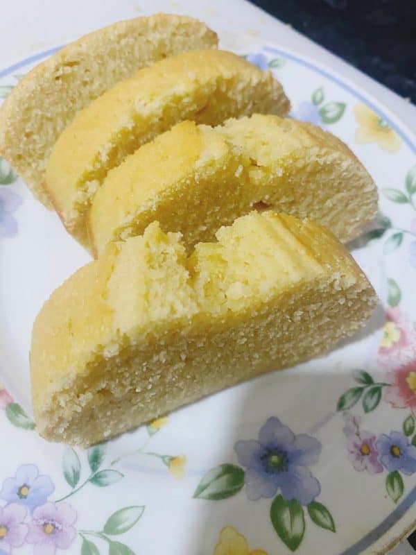 Sliced golden sponge cake neatly arranged on a white board.