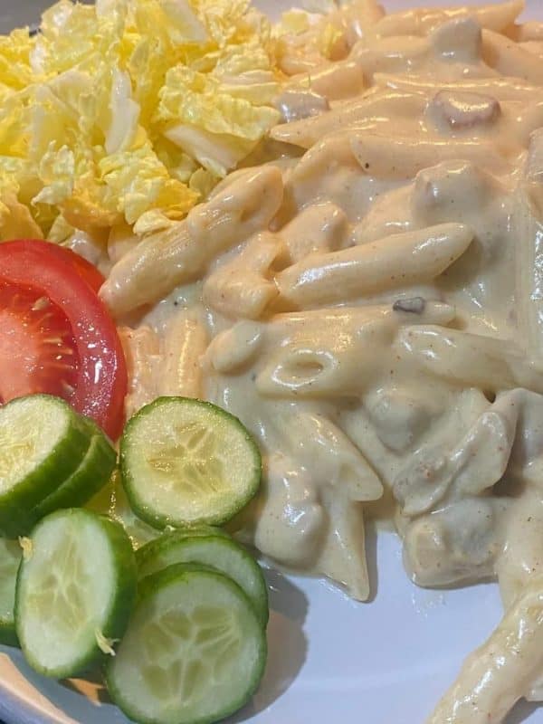 Fresh pork ribs with pasta, Chinese cabbage, pasta sauce, soy sauce, and spices arranged on a kitchen counter