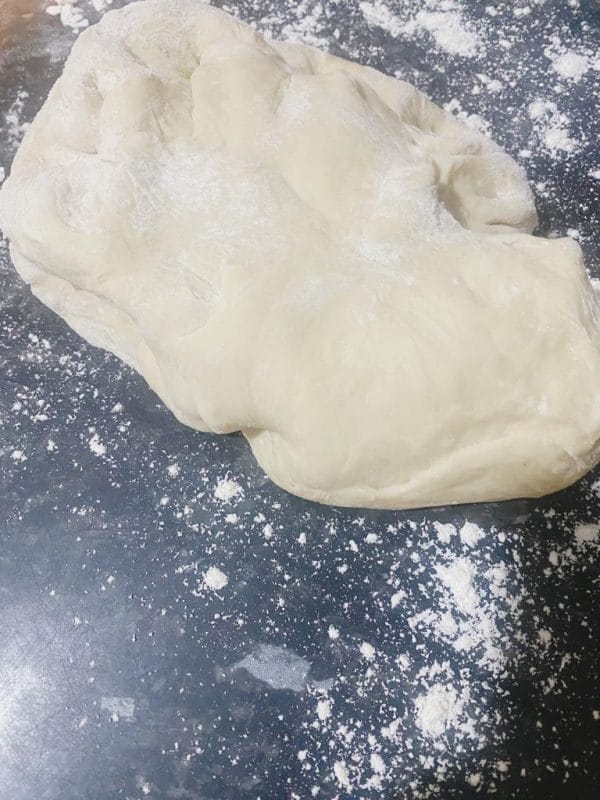 Risen dough resting on a floured surface.