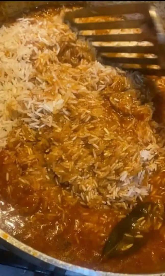 Tomato-coated rice simmering in the pot, soaking up flavors.