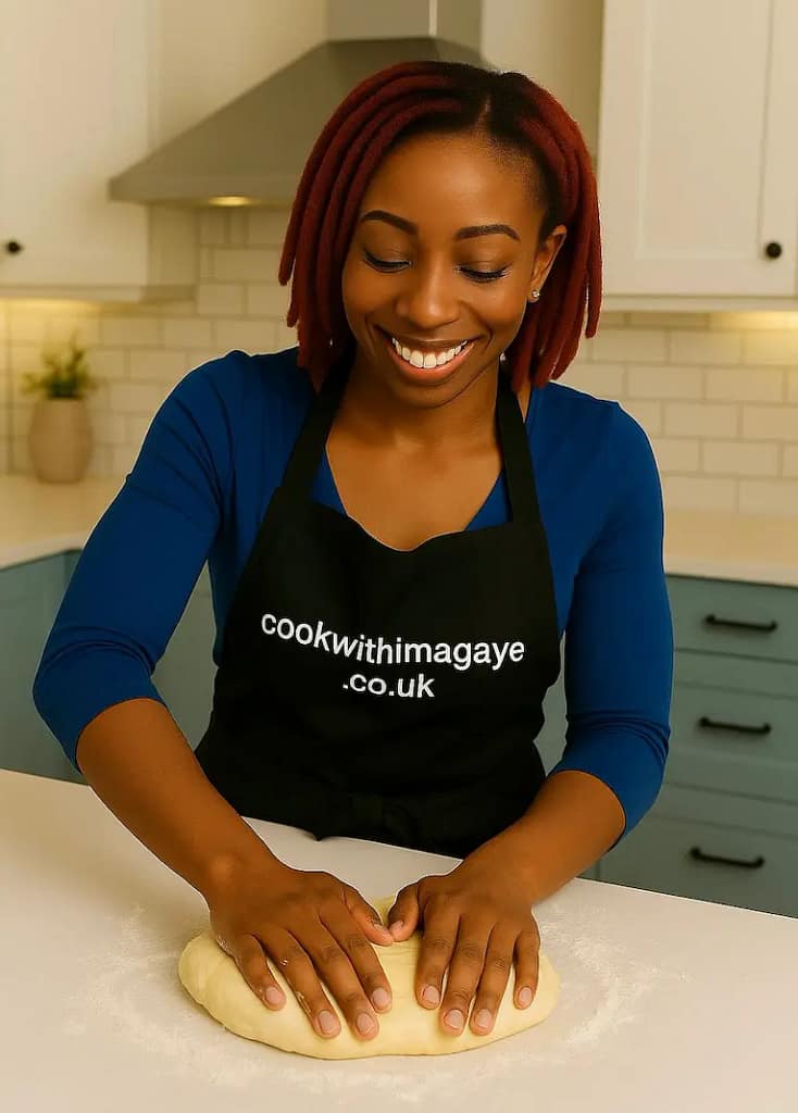 Woman kneading dough on a floured surface in a kitchen.