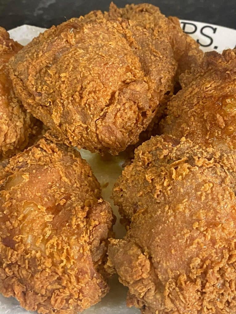 Crispy golden brown chicken thighs resting on paper towels.