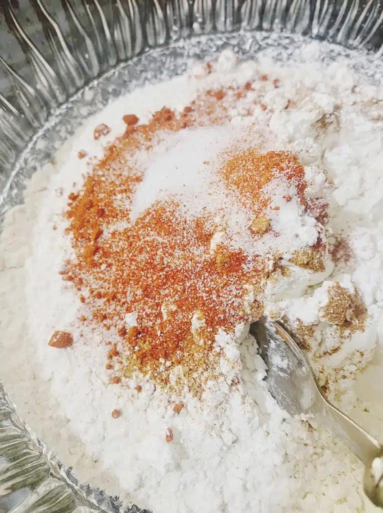 Flour and spices in a mixing bowl for crispy chicken coating.