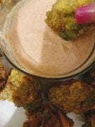 Fried prawn pakoras plated with dipping sauce on the side.