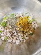 Alt Text: Ingredients like chopped prawns, onions, and spices placed in a mixing bowl.