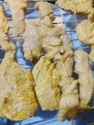 Oven-roasted chicken pieces with golden brown skin on a lined tray, just taken out of the oven.