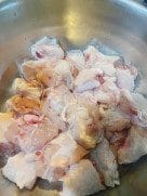 Marinated chicken wings in a bowl with soy sauce, vinegar, and salt