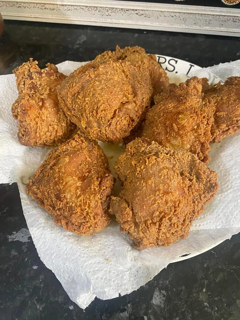 Crispy golden brown chicken thighs resting on paper towels.