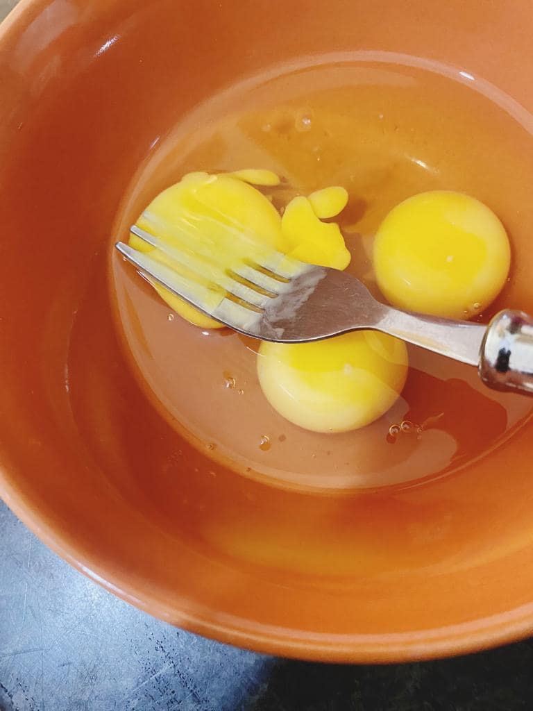 Whisking eggs in a bowl for a fluffy omelette